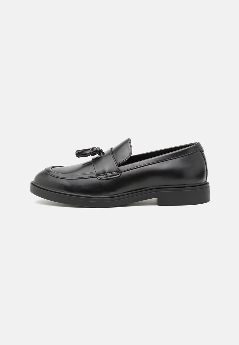 Svarta läderloafers med en slät finish, med en dekorativ risknopp framtill och en låg, texturerad gummisula.