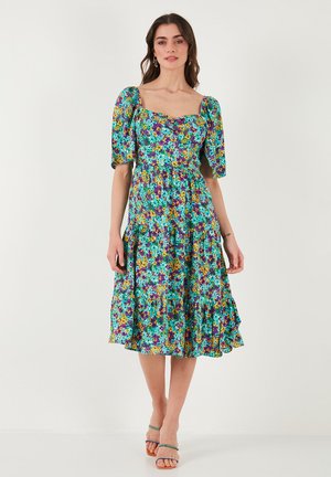 Floral midi dress with a square neckline, puffed sleeves, layered ruffles, featuring a vibrant mix of purple, blue, yellow, and green colors.