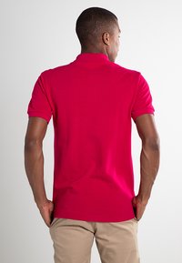 Rode polo-shirt met korte mouwen en kraag, met een zachte katoenstructuur en een rechte zoom.