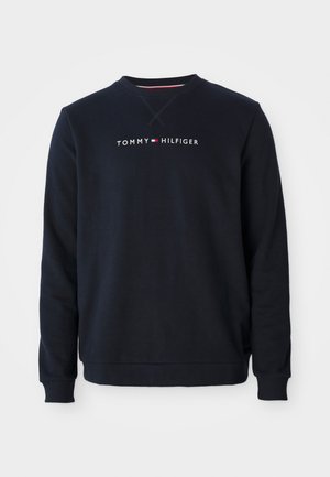 Marineblaue Rundhalsausschnitt-Sweatshirt mit gerippten Bündchen und Saum, mit dem "Tommy Hilfiger"-Logo und dem Flaggenemblem in der Mitte der Brust.