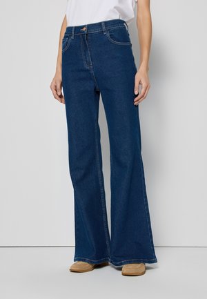 Hoge taille, flared jeans in donkerblauwe denim, met standaardzakken en contrasterende stiksels. Zachte textuur en ontwerp in volle lengte.