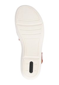Semelle d'une chaussure, fabriquée en caoutchouc avec un motif texturé. La couleur est blanche avec un logo noir et des accents rouges sur les côtés.