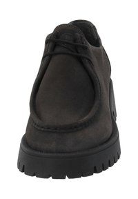 Black suede shoe with a rounded toe, minimal stitching, and lace-up detail; features a chunky rubber sole for grip and durability.