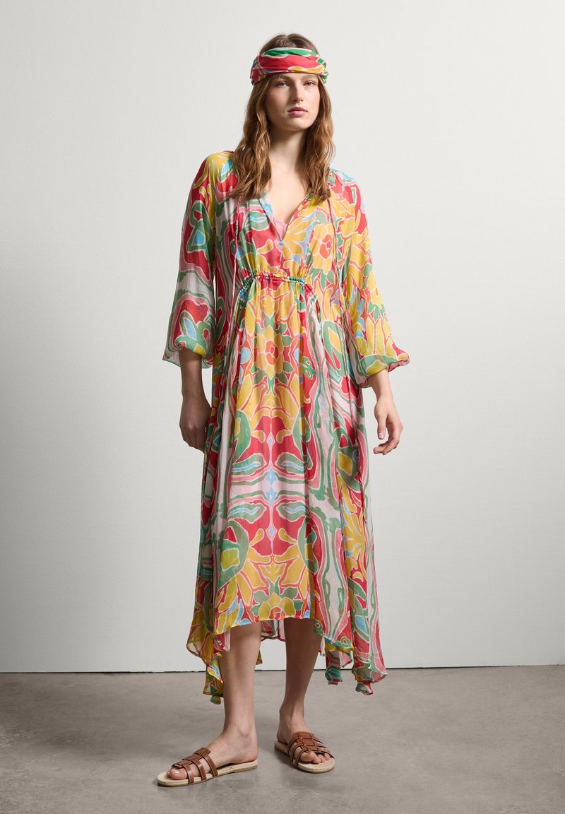 Fließendes Kleid aus leichtem Stoff mit einem lebhaften Blumenmuster in Rot, Gelb und Grün. Lange Ärmel und asymmetrischer Saum.