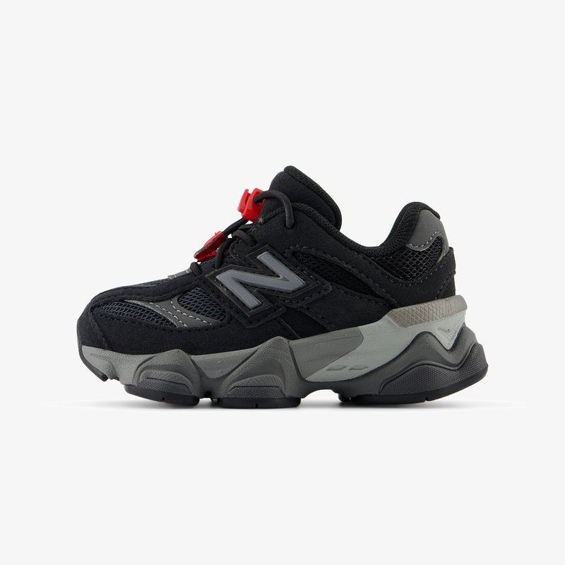 Fekete sportcipők szürke kiegészítőkkel, texturált felső résszel, hálós panelekből, és piros húzófűzős zárással. Vastag, párnázott talp.