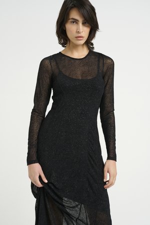 Black long-sleeve dress in sheer, sparkly fabric with a rounded neckline and fitted bodice, featuring draped detailing at the skirt.