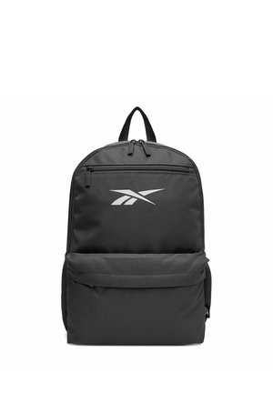 Mochila negra con bolsillo frontal con cremallera, asa superior, bolsillos laterales de malla y logo blanco de Reebok en el panel frontal.