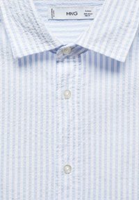 Světle modrá a bílá pruhovaná košile s klasickým límcem, vybavená knoflíkovým zapínáním a kulatými knoflíky; měkká bavlněná textura.