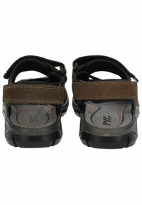 Bruine leren sandalen met verstelbare banden, gestructureerde binnenzolen en rubberen zolen. Uitgerust met padding voor comfort en rode accenten op de binnenzool.