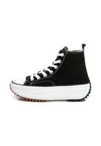 Zapatillas altas negras con parte superior de lona, cordones blancos, puntera de goma y una suela gruesa y esculpida con una suela exterior en tonos marrón y negro.