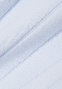 Weiches hellblaues Gewebe mit sichtbarer Webstruktur und diagonalen Falten, die Schatten und Tiefe erzeugen.