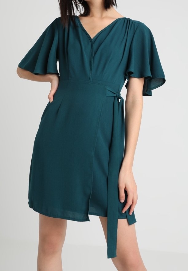 Robe portefeuille bleu sarcelle en tissu léger, avec des manches courtes volantées, un décolleté en V, une ceinture à la taille et une jupe légèrement évasée.