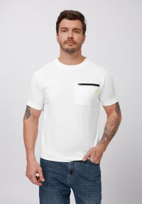 White short-sleeve cotton t-shirt featuring a black zippered pocket on the left chest and a small yellow logo above the pocket.