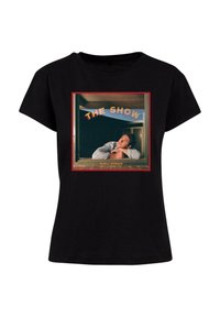 Tricou din bumbac negru cu un imprimeu grafic care conține textul "THE SHOW" și o persoană privind pe fereastră, încadrată în roșu.