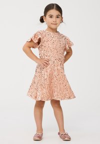 Różowa sukienka z cekinami z krótkimi falbankami, marszczoną górą, rozkloszowanym dołem i pasującymi różowymi, błyszczącymi butami. Gładka tekstura z błyszczącymi akcentami.