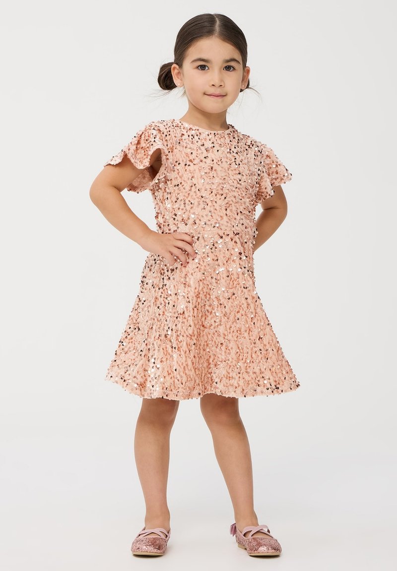Różowa sukienka z cekinami z krótkimi falbankami, marszczoną górą, rozkloszowanym dołem i pasującymi różowymi, błyszczącymi butami. Gładka tekstura z błyszczącymi akcentami.