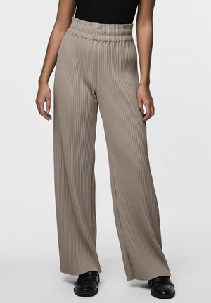 Beige, high-waisted, wide-leg trousers with vertical ribbed texture, elastic waistband, and lightweight fabric. Paired with black shoes.