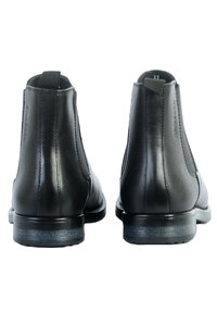 Stivali alla caviglia in pelle nera con finitura liscia, pannelli laterali elasticizzati e tacco basso. Include linguette per un facile indossamento.