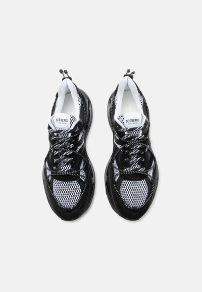 Μαύρα και λευκά αθλητικά παπούτσια από δίχτυ με χοντρές σόλες, σχέδιο με κορδόνια και λαβές στον αστράγαλο, με την επιγραφή "ICEBERG since 1974" στη γλώσσα.