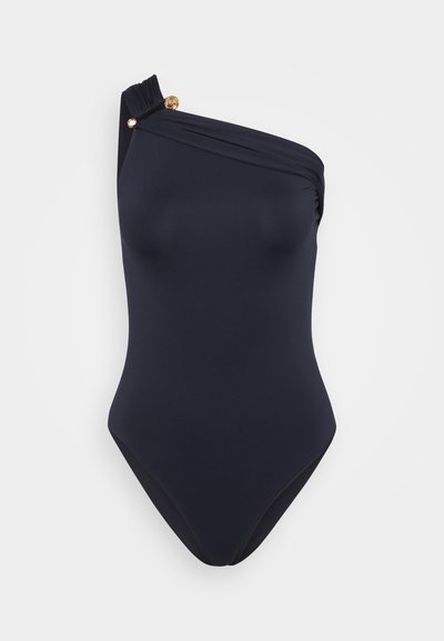 Merenneito yksiolkaiminen uimapuku, jossa on drapeerattua kangasta ja kultainen yksityiskohta olkaimessa lisäyksenä.