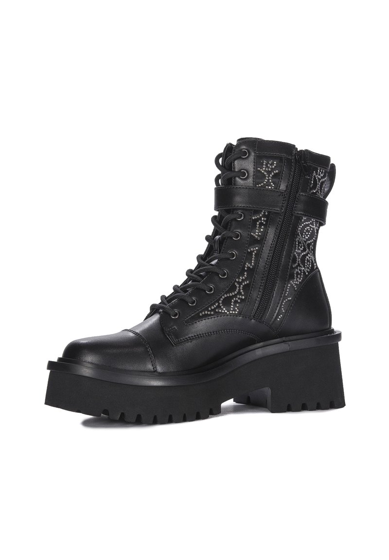Bottines en cuir noir avec une semelle chunky, des détails en lacets, une fermeture éclair sur le côté et des clous décoratifs sur les côtés extérieurs.