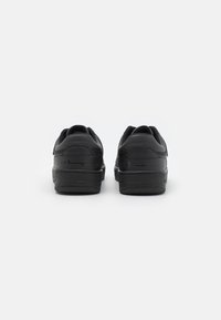 Svarta sneakers med en slät läderöverdelsämne, med rund tå, vadderad krage och texturerad gummisula. Pr präglad logotyp på hälen.