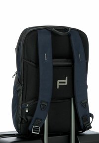 Zaino nero e blu con spallacci imbottiti, pannelli in rete e dettagli metallici, dotato di cerniere e un logo sul retro.