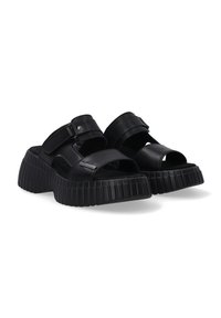 Zwarte leren platform sandalen met een open teen, voorzien van twee verstelbare banden en een gestructureerde, ribbelige zool voor stabiliteit.