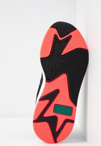 Gummiskosula med en svart och neonrosa design. Har strukturerade mönster, vågiga spår och en grön logolapp med texten "RUNNING SYSTEM."