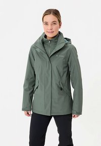 Groene waterdichte jas met capuchon, ritssluiting aan de voorkant en twee zijzakken. Gemaakt van lichtgewicht stof met een gladde textuur en minimale branding.