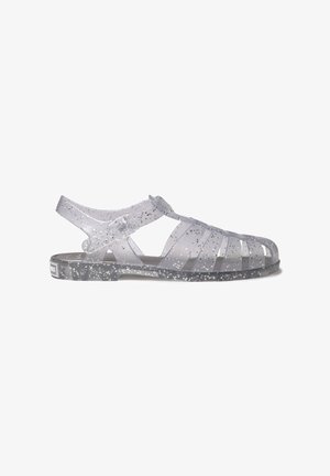 Transparante jelly sandalen met een open ontwerp, voorzien van een gevlekte patroon, verstelbare band en een textuurlijk zool voor grip.