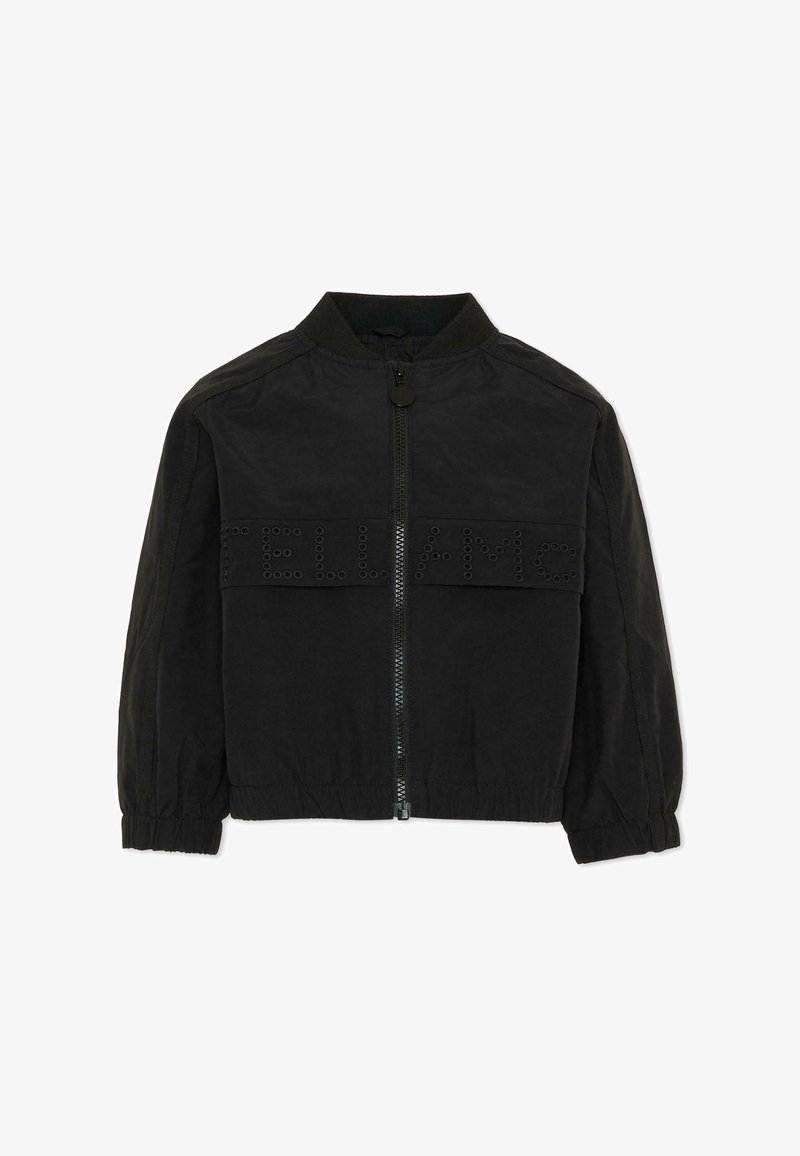 Veste bomber noire zippée avec poignets et ceinture élastiques, ornée de petits rivets ronds formant l'inscription "TELLA MC" sur la poitrine.