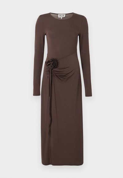 Μακρυμάνικο, στενό φόρεμα σκούρου καφέ με στρογγυλή λαιμόκοψη και ριμπαριστή λεπτομέρεια, αναδειγμένη από ένα υφασμάτινο τριαντάφυλλο στην αριστερή μέση.