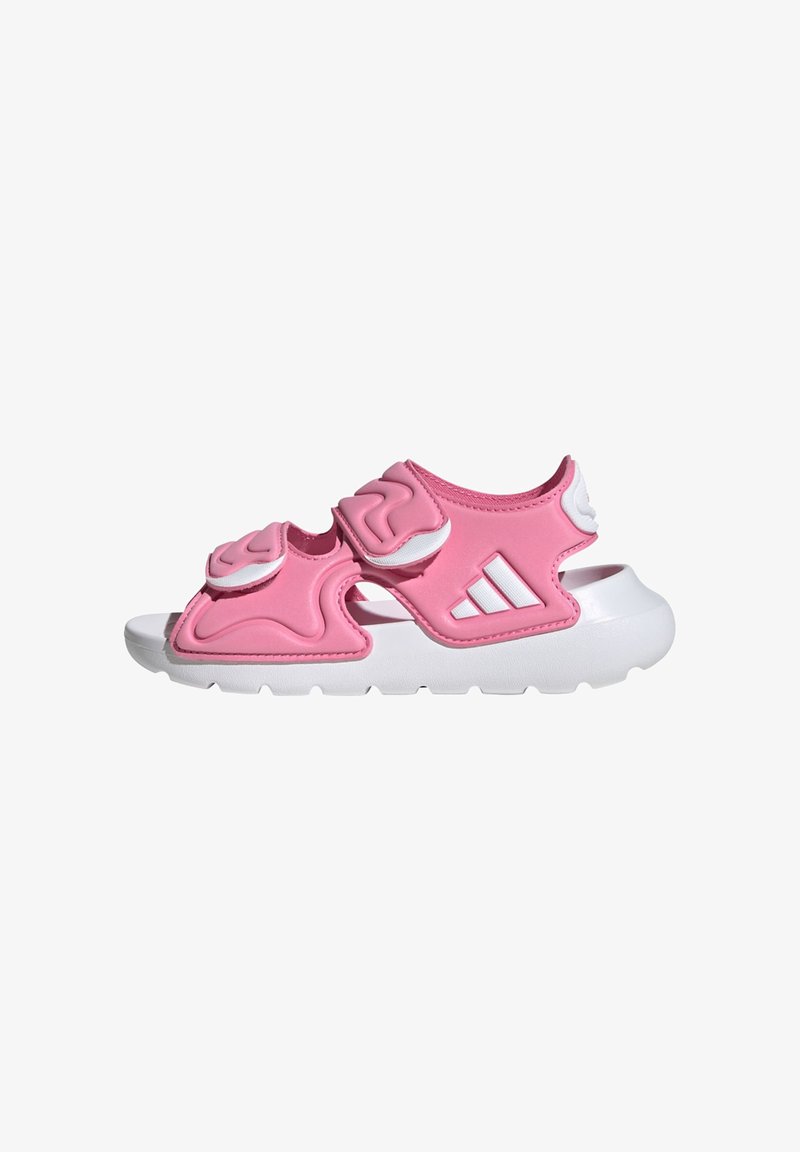 Ružové športové sandále s bielymi akcentmi, vyrobené z flexibilného materiálu, s dvoma nastaviteľnými remienkami a textúrovanými detailmi na hornej časti.