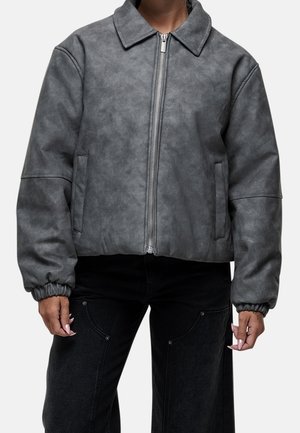 Szara kurtka ze sztucznej skóry z kołnierzem, zapięciem na zamek i elastycznymi mankietami. Posiada boczne kieszenie i krótki fason.