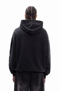 Μαύρο φαρδύ φούτερ με μεγάλο κουκούλι και χαμηλωμένους ώμους. Διαθέτει υφασμάτινη υφή και ριμπ μανσέτες, σε συνδυασμό με σκούρο τζιν.