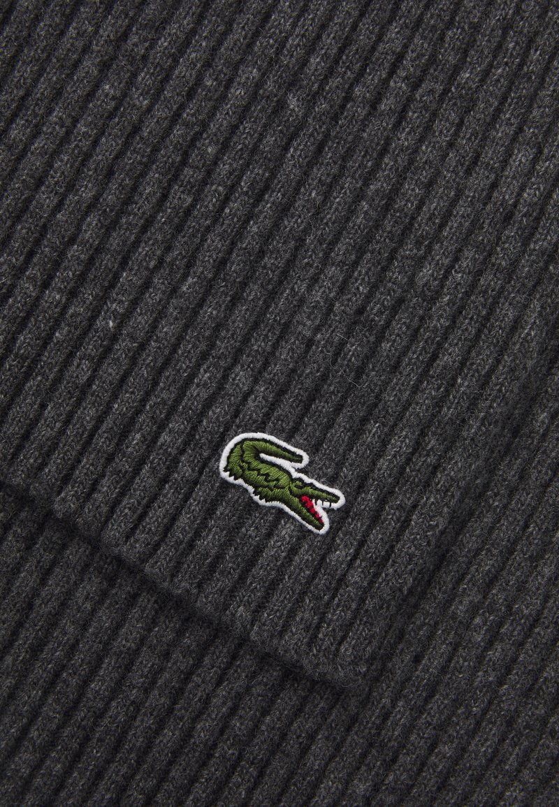 Gray ribbed knit scarf made of wool, featuring a green and red crocodile logo patch on a white background, highlighting texture and design.