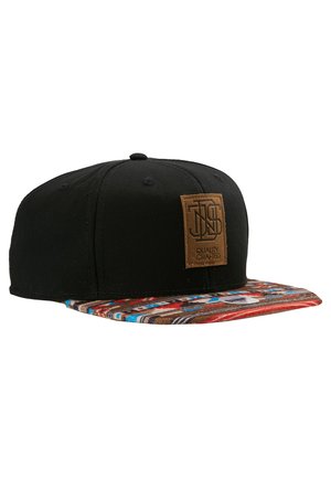 Snapback skrybėlė su juodu kanvos kūnu ir raštuotu virkštelės kraštu, kuriame matomi raudoni, mėlyni ir rudi dryžiai. Įtrauktas rudasis odinis logotipo ženklas.