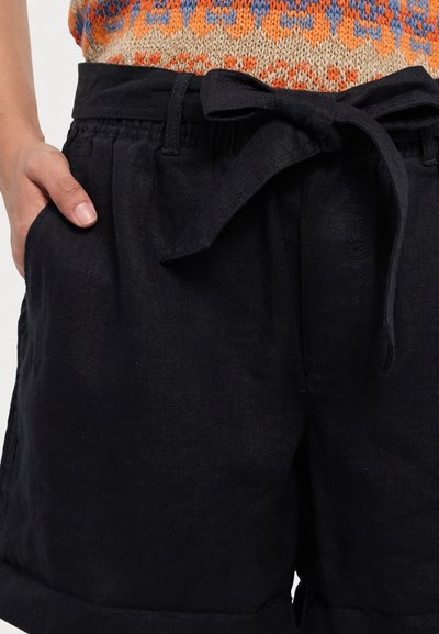 Pantaloni scurți din in negri, cu un brâu lat, buzunare frontale și o curea legată. Textura materialului este netedă și ușor șifonată.