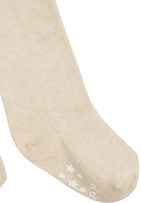 Calzini di cotone beige con texture a costine, punta arrotondata e motivi a stella e pallini stampati bianchi sul fondo per una migliore aderenza.