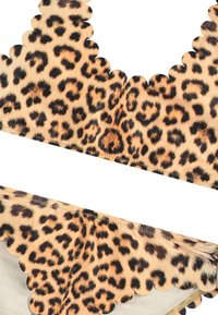 Bikinová podprsenka s leopardím vzorom, ktorá má zvlnené okraje, vyrobená z mäkkej textílie s tlmeným béžovým pozadím pre kontrast.
