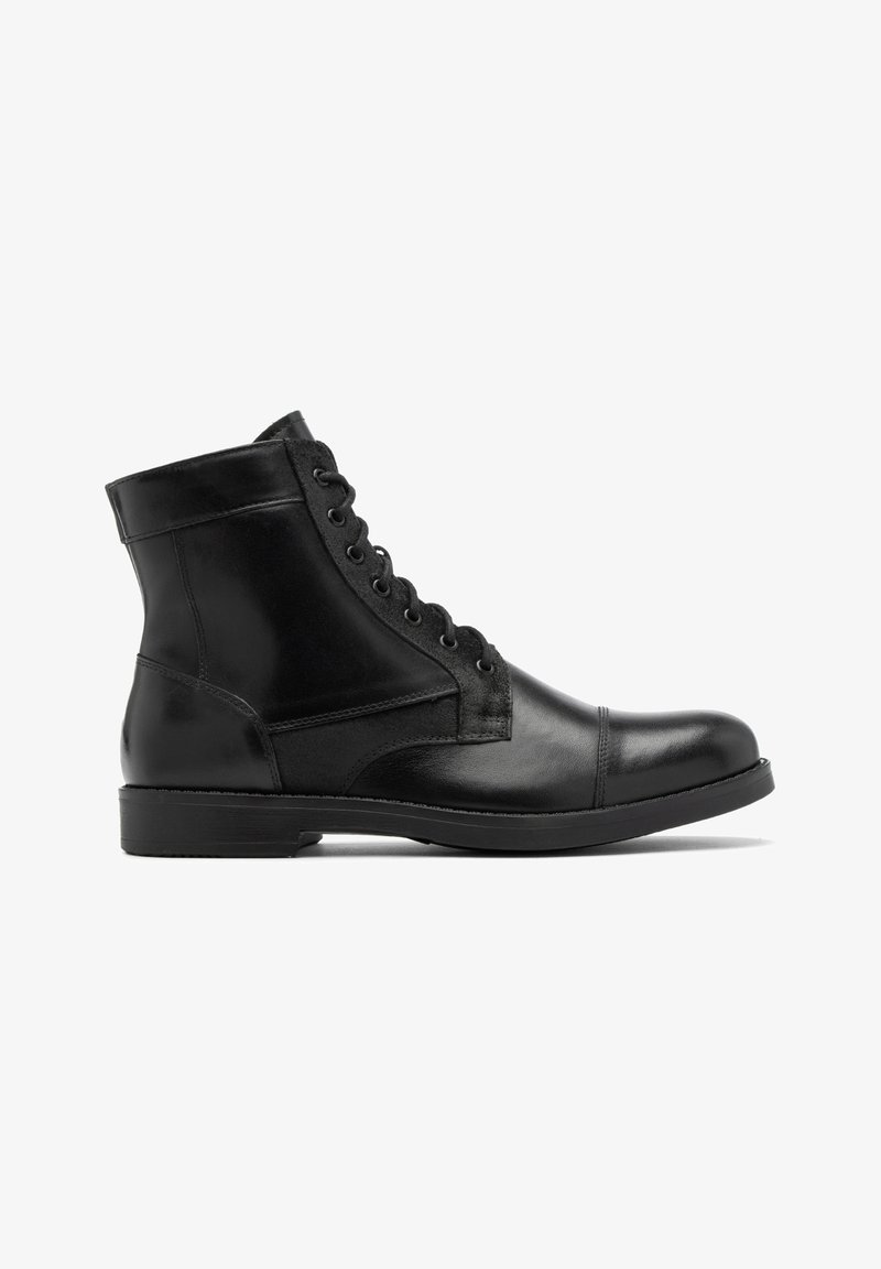 Czarne skórzane botki za kostkę o gładkim wykończeniu, z okrągłym czubkiem i sznurowanym designem. Zawierają detale w postaci szwów oraz solidną gumową podeszwę.