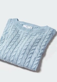 Pull en maille torsadée bleu clair, soigneusement plié, avec une étiquette de marque MNG visible à l'intérieur du col, posé sur un fond blanc.