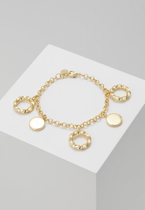 Złota bransoletka z łańcuszkiem, z naprzemiennie ułożonymi skręconymi kółkami i gładkimi okrągłymi zawieszkami na białym tle.