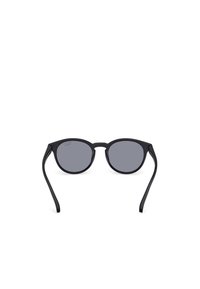 Černé sluneční brýle s kulatými rámy a šedými skly. Rámky jsou štíhlé a rovné, vyrobené z plastu. Minimalistický design, žádné viditelné ozdoby.