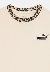 Kréma krāsas t-kreklis ar īsām piedurknēm, kas rotāts ar leopardu printa apkakli, melnu "PUMA" logotipu un mīkstu tekstūru.