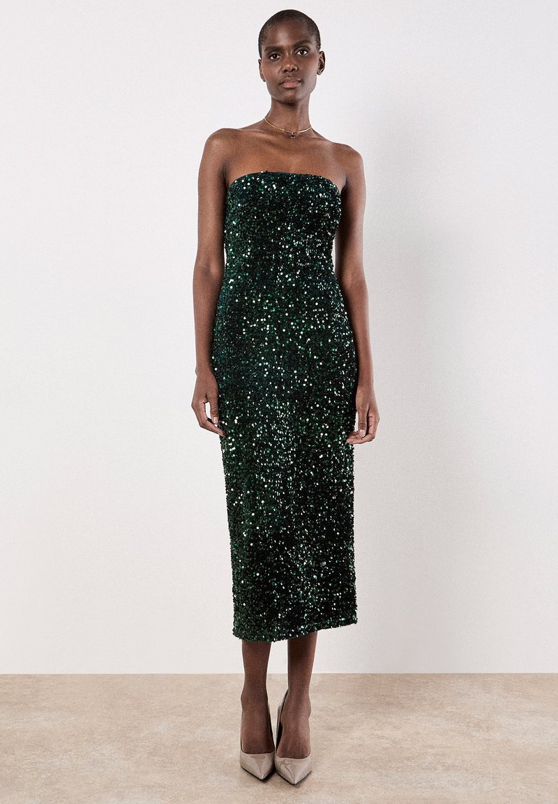 Ohne Träger grünes Pailletten-Midi-Kleid mit einer figurbetonten Silhouette, glatter Textur und subtiler Schimmerung, kombiniert mit hellbeigen High Heels.