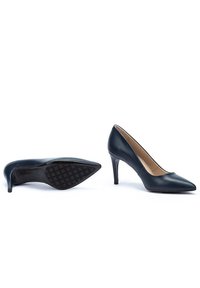 Scarpe nere in pelle con tacco alto, punta affilata, finitura liscia e suola texturizzata per una migliore aderenza. Altezza del tacco moderata.