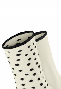 Weiße Socken mit schwarzen Punkten, gerippter Textur und schwarzem Saum oben. Das Muster ist gleichmäßig über den Stoff verteilt.