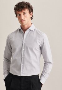 Gestreifte Button-up-Bluse aus Baumwolle, mit vertikalen blauen und weißen Streifen, langen Ärmeln und klassischem Kragen. Taillierte Passform.